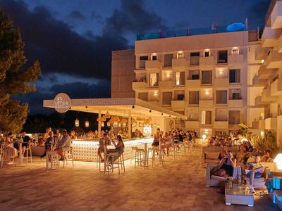 Hotelterras met verlichte bar en gasten 's nachts