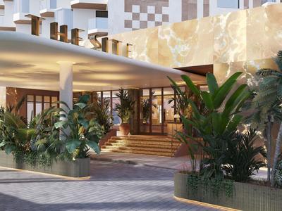 Hotel entrance area with tropical plants and modern architecture.