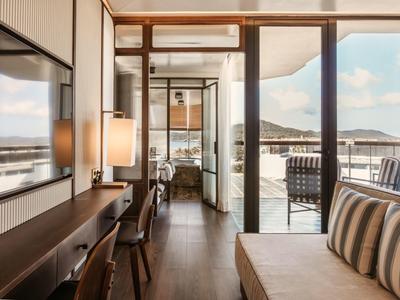 Modern hotel room with terrace and view of mountains and sky