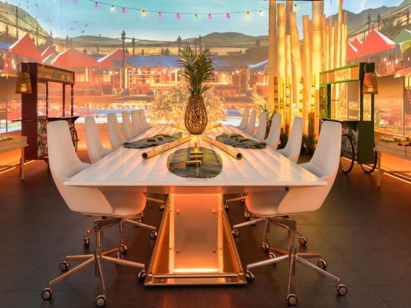 Elegant meeting room with white table and chairs, warm lighting, and city view.