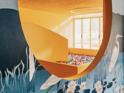 Piscina de bolas colorida visible a través de un gran espejo circular en un espacio con paredes azul y amarillo.