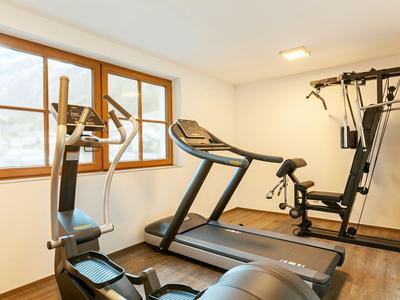 Modern ausgestatteter Fitnessraum mit verschiedenen Trainingsgeräten in einem Hotel.