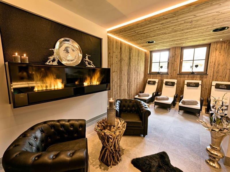 Sala de bienestar moderna con sillones de cuero, sillas de masaje y luz cálida de chimenea