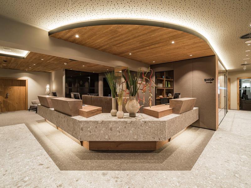 Modern hotel lobby with curved ceiling lighting and stylish seating areas.