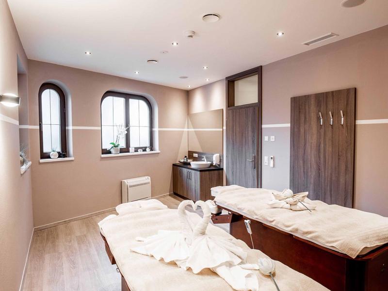 Bright wellness room with two massage tables and large windows