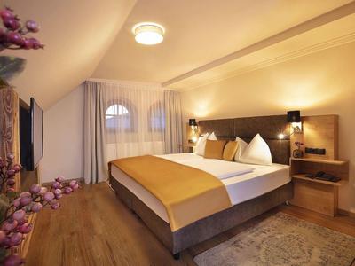 Gezellige hotelkamer met tweepersoonsbed, warme houttinten en stijlvolle verlichting.