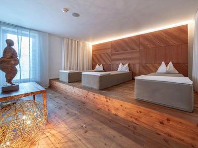 Moderne hotelkamer met twee eenpersoonsbedden, houten vloer en decoratief beeld op tafel.