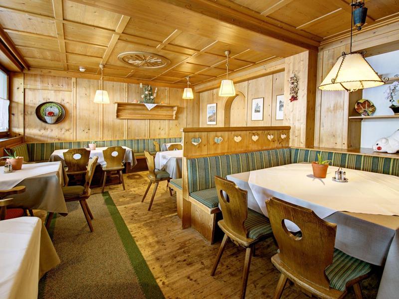 Traditionelles Gasthaus mit Holztäfelung, gedeckten Tischen und warmem, gemütlichem Ambiente.