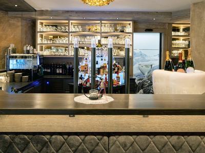 Moderne Hotelbar mit stilvollem Tresen, Beleuchtung und Getränkeregalen im Hintergrund