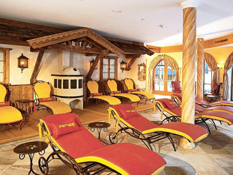 Gezellige ontspanningsruimte met veel rode en gele ligstoelen en een kleine open haard.