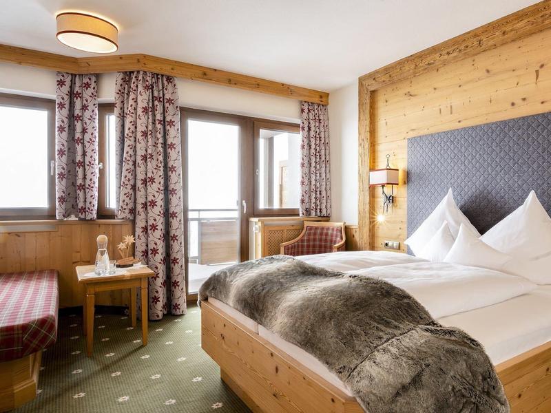 Gezellige hotelkamer met houten meubels, bed, vensterbank en gordijnen.