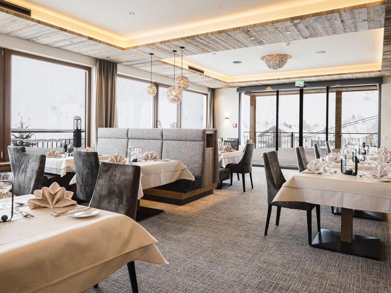 Elegant restaurant met gedekte tafels, grote ramen en gezellige zitplaatsen.