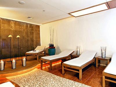 Relaxation room with loungers, stylish wooden furniture, and a calm atmosphere in a spa.