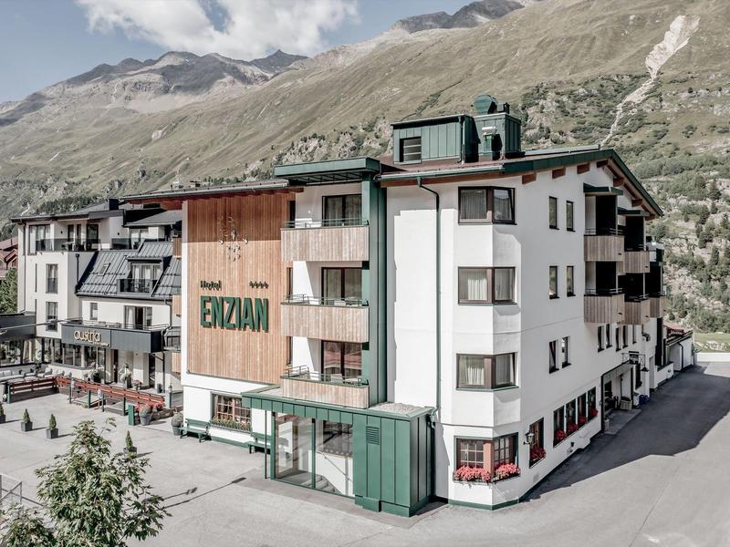 Hotel in the mountains with traditional architecture and surrounding mountain landscape.