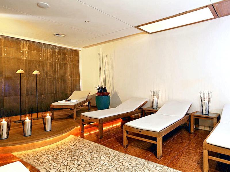 Relaxation room with loungers, stylish wooden furniture, and a calm atmosphere in a spa.