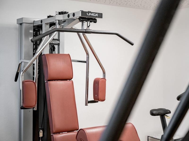 Red fitness machine for chest and arm muscles indoors.