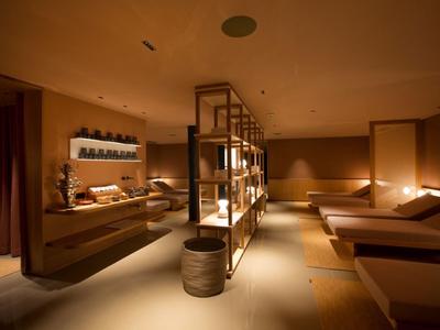 Sala de spa cálida y con luz tenue con camillas y decoración relajante.