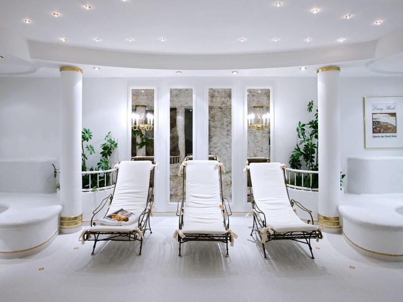 Sala blanca con tres tumbonas y elementos decorativos modernos en un hotel.