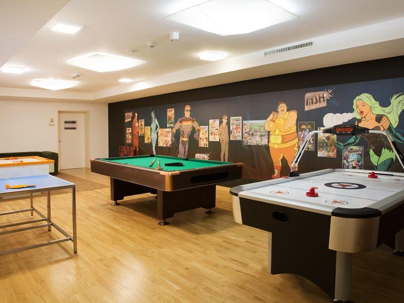 Sala de juegos con billar, air hockey y tenis de mesa en un hotel.