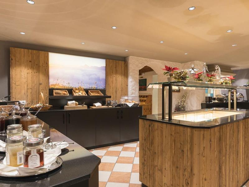 Gemütlicher Frühstücksraum mit Holzmöbeln, Buffetinsel und Kaffeetassen auf Tellern.