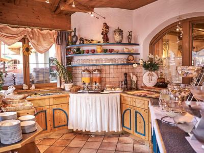 Acogedora zona de desayuno con muebles de madera y un buffet bien surtido bajo luz cálida.