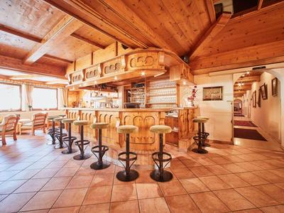 Gemütliche Holzbarkeeper mit Hockern und viel Tageslicht in rustikalem Raum.