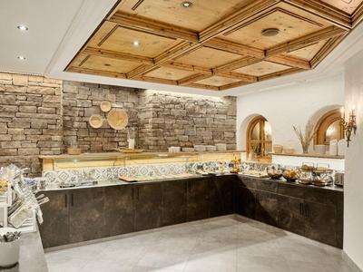 Elegante Küchenzeile mit Steinmauer, Holzbalkendecke und warmen Lichtakzenten.