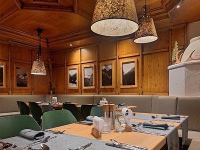 Acogedor comedor con paneles de madera, mesas preparadas y cuadros en las paredes.