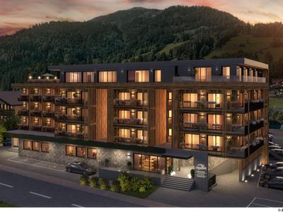 Modernes Hotelgebäude mit Beleuchtung in einer Berglandschaft bei Sonnenuntergang.