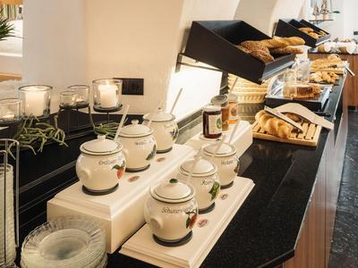 Buffet met verschillende gebakjes en jampotten op een zwart aanrecht.