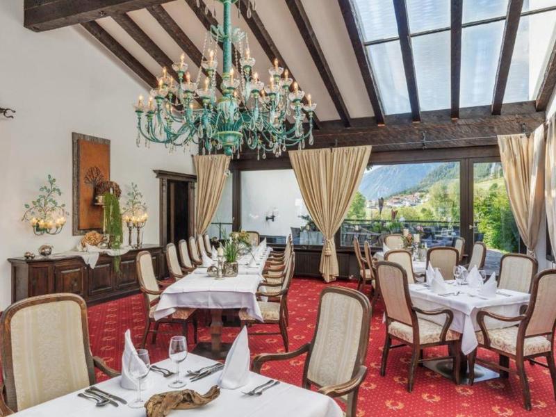 Elegantes Restaurant mit hohen Decken, großen Fenstern und rotem Teppichboden.
