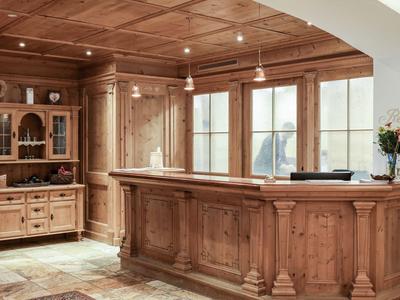 Rustikaler Empfangsbereich mit Holztheke und Schrank in einem Hotel.