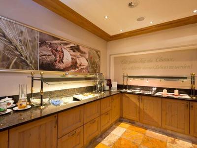 Buffetbereich mit Holzschränken, Kaffee- und Teeangebot sowie einer großen dekorativen Wandkunst.