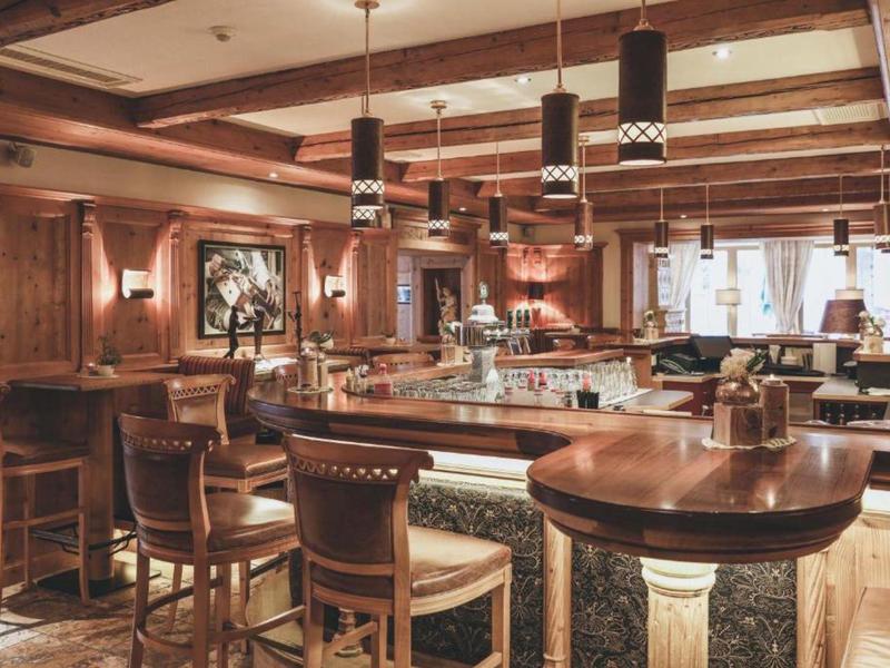 Gemütliche Hotelbar mit Holzdecke, Ledersesseln und stilvoller Beleuchtung.