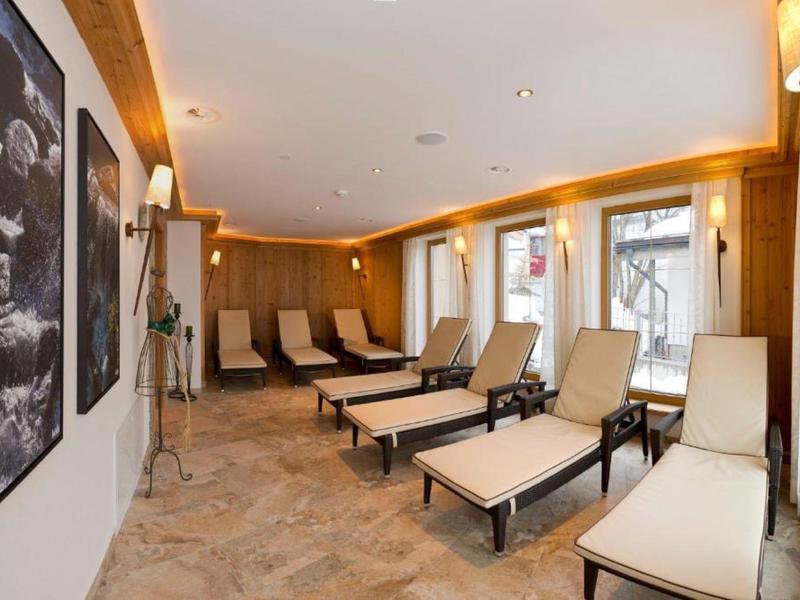 Gemütlicher Wellnessraum mit Liegestühlen, Holzwänden und stimmungsvoller Beleuchtung.