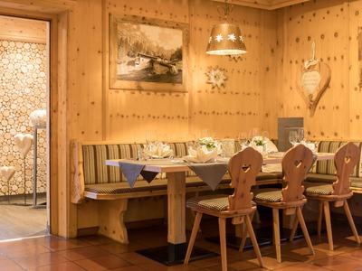 Cozy wooden corner with table, bench, and chairs in traditional style
