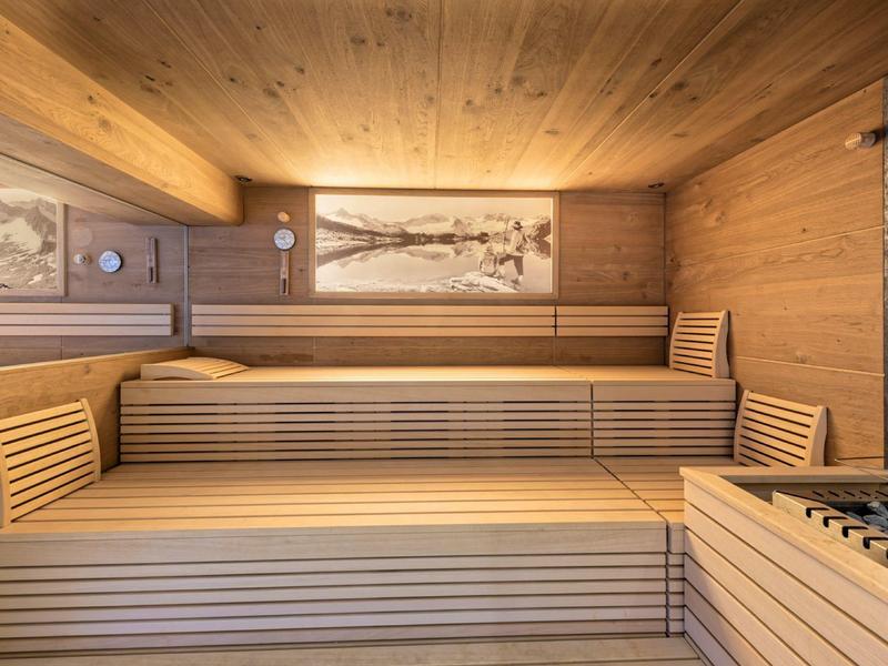 Holzsauna mit mehrstufigen Sitzbänken und indirekter Beleuchtung an den Wänden.