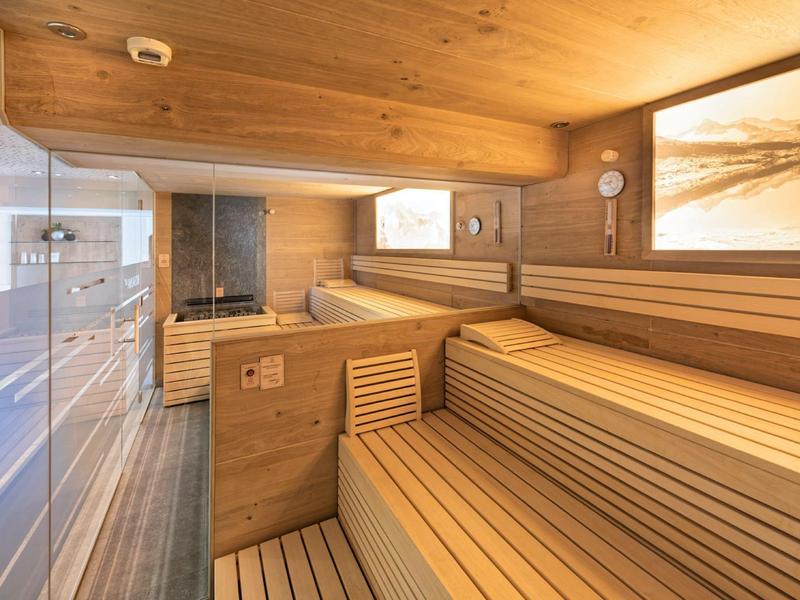 Innenansicht einer modernen Sauna mit Holzbänken und indirekter Beleuchtung.