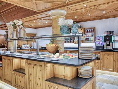 Buffet area with wooden counter, various dishes, and tableware in a rustic setting.