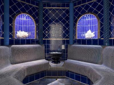 Luxuriöser Spa-Ruheraum mit blauen Kacheln und zwei Fenstern mit künstlichem Licht.