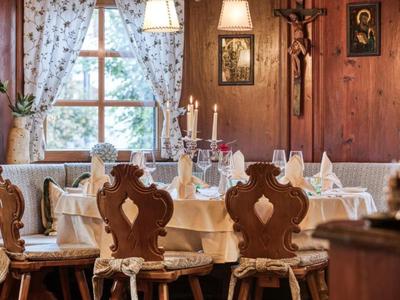 Gemütlicher Essbereich mit Holzstühlen und einer gedeckten Tafel neben einem Fenster mit hellen Vorhängen.