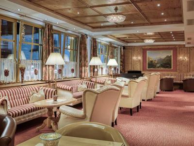 Gemütlicher Lounge-Bereich mit Sitzgruppen, warmem Holzdekor und gedämpfter Beleuchtung