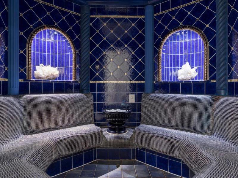 Luxuriöser Spa-Ruheraum mit blauen Kacheln und zwei Fenstern mit künstlichem Licht.