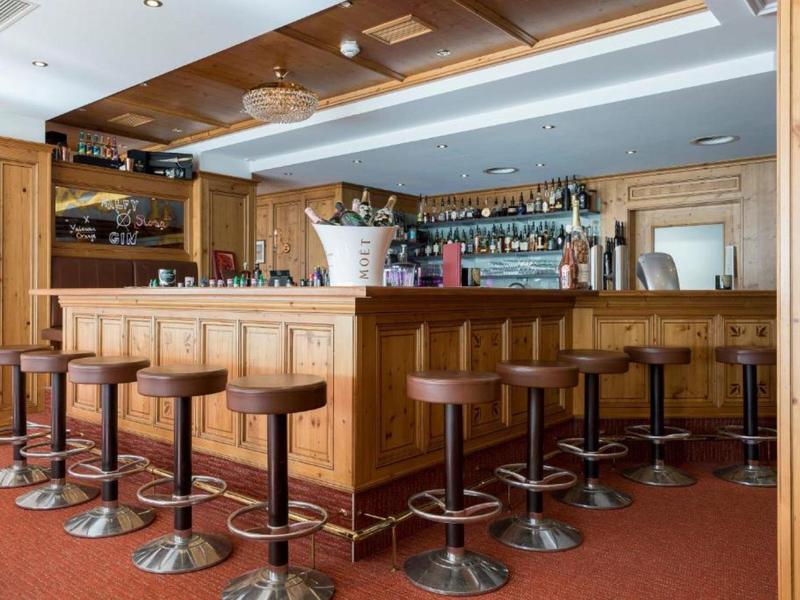 Barbereich mit Holzverkleidung und Hockern in einem Hotelambiente.