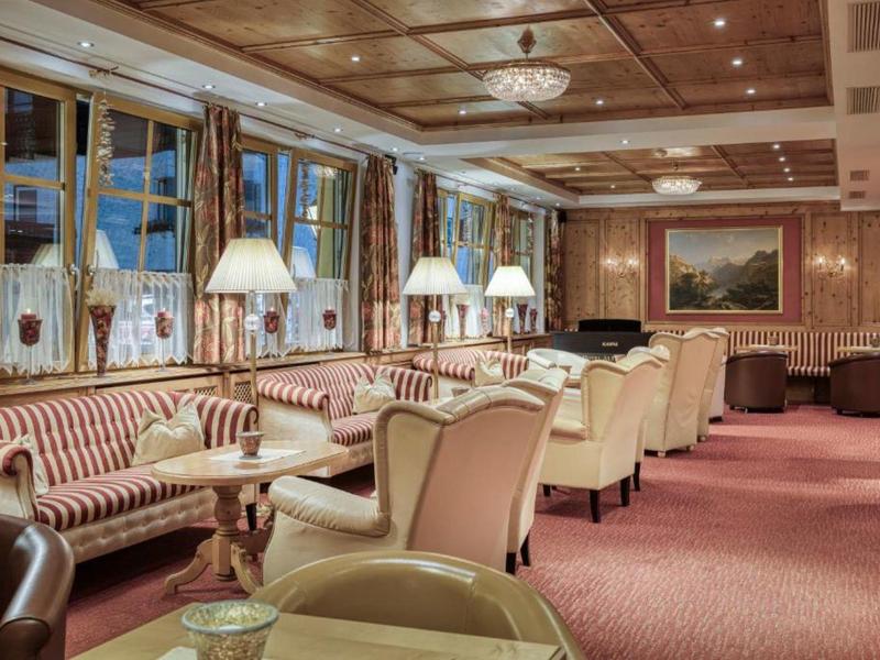 Gemütlicher Lounge-Bereich mit Sitzgruppen, warmem Holzdekor und gedämpfter Beleuchtung