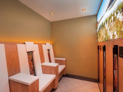 Modern, simple seating area in a hotel with warm lighting and illuminated wall art.
