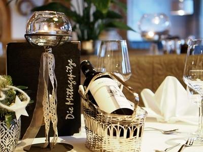 Eleganter gedeckter Tisch mit Weinglas, Servietten und Weinflasche in einem Restaurant.