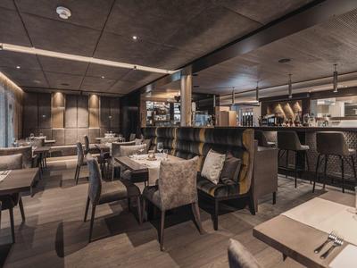 Modern furnished restaurant with wooden furniture and subdued lighting.