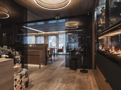 Modern hotel lounge area with wooden ceilings, fireplace, and stylish lighting