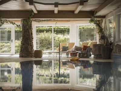 Beheizter Innenpool in gemütlichem Hotel mit Holzdecken und Sitzbereich